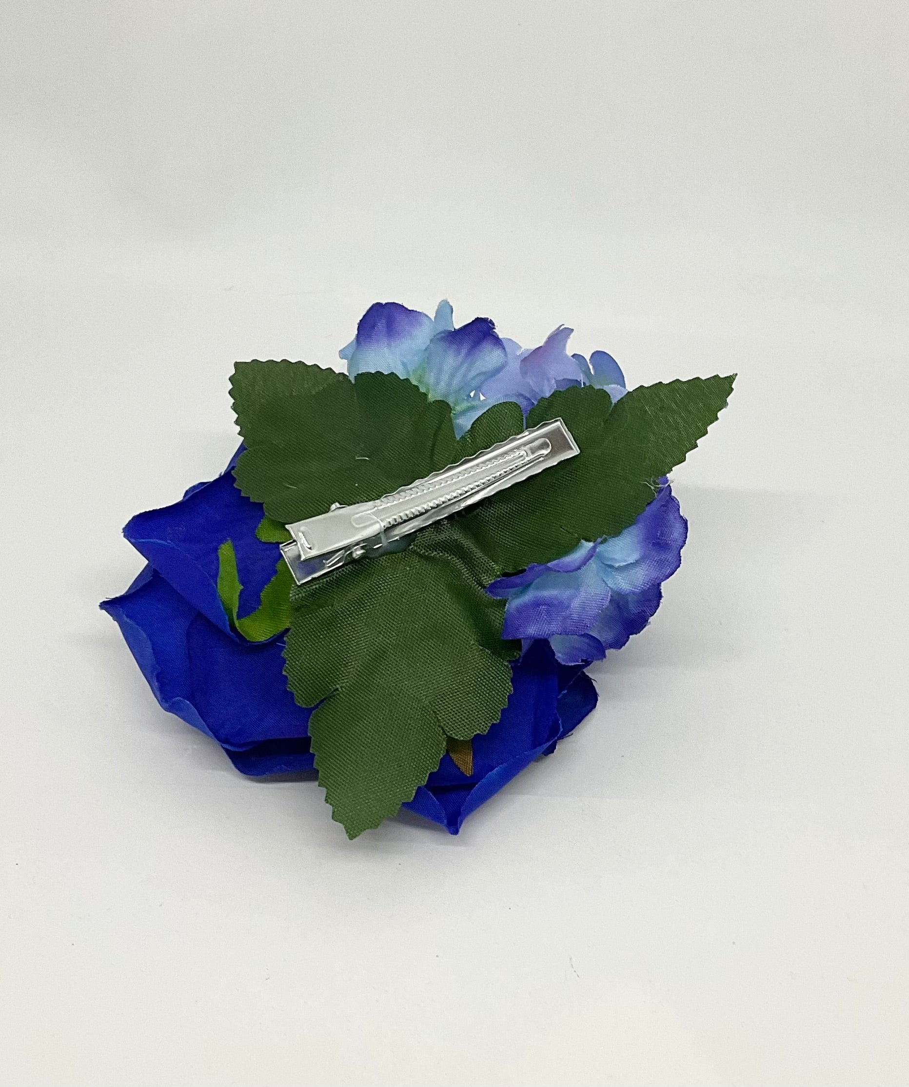 Blue fantasy rose hair flower with a green stem, accompanied by smaller purple flowers Pin-up vintage hair styling