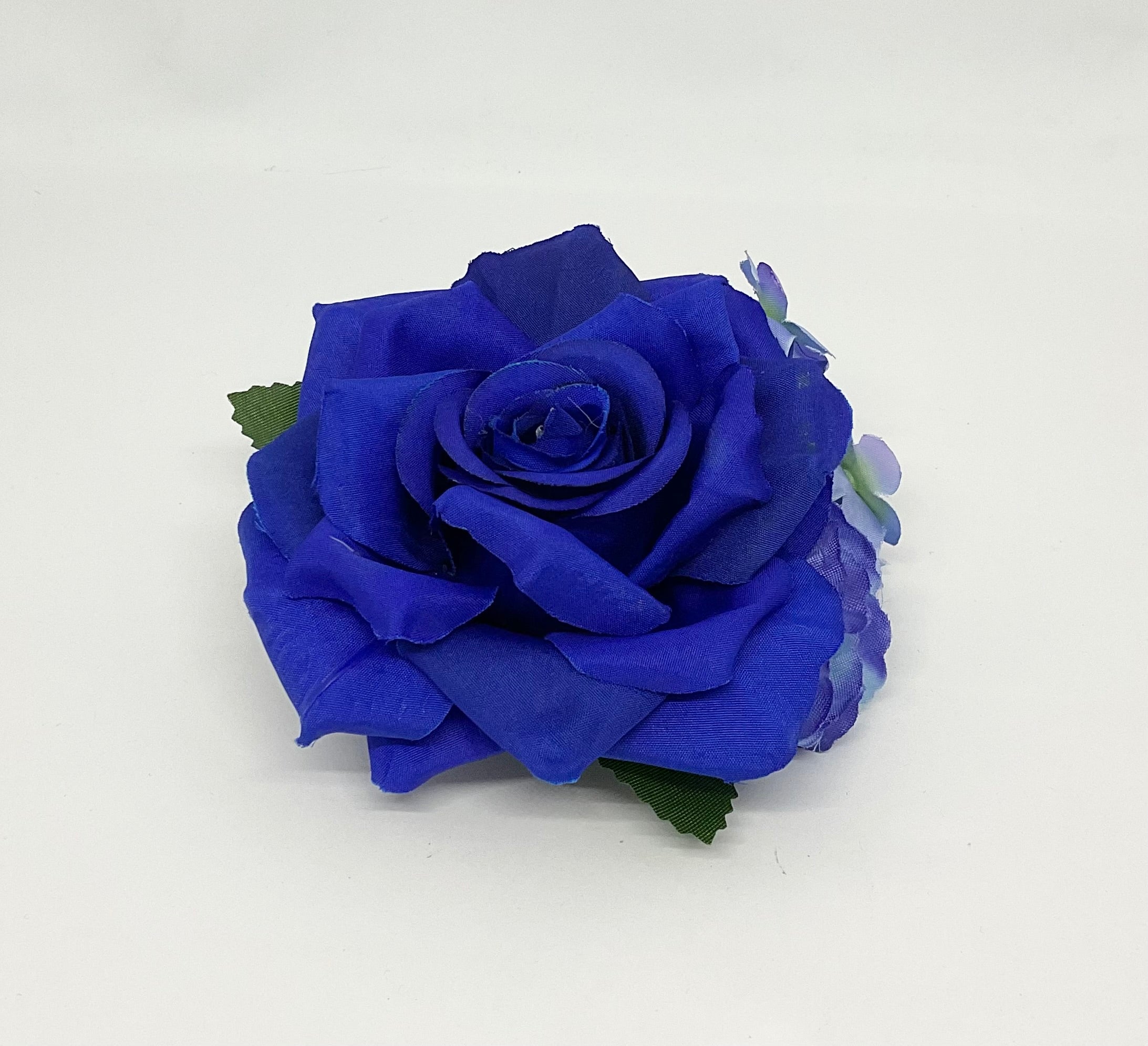 Blue fantasy rose hair flower with a green stem, accompanied by smaller purple flowers Pin-up vintage hair styling
