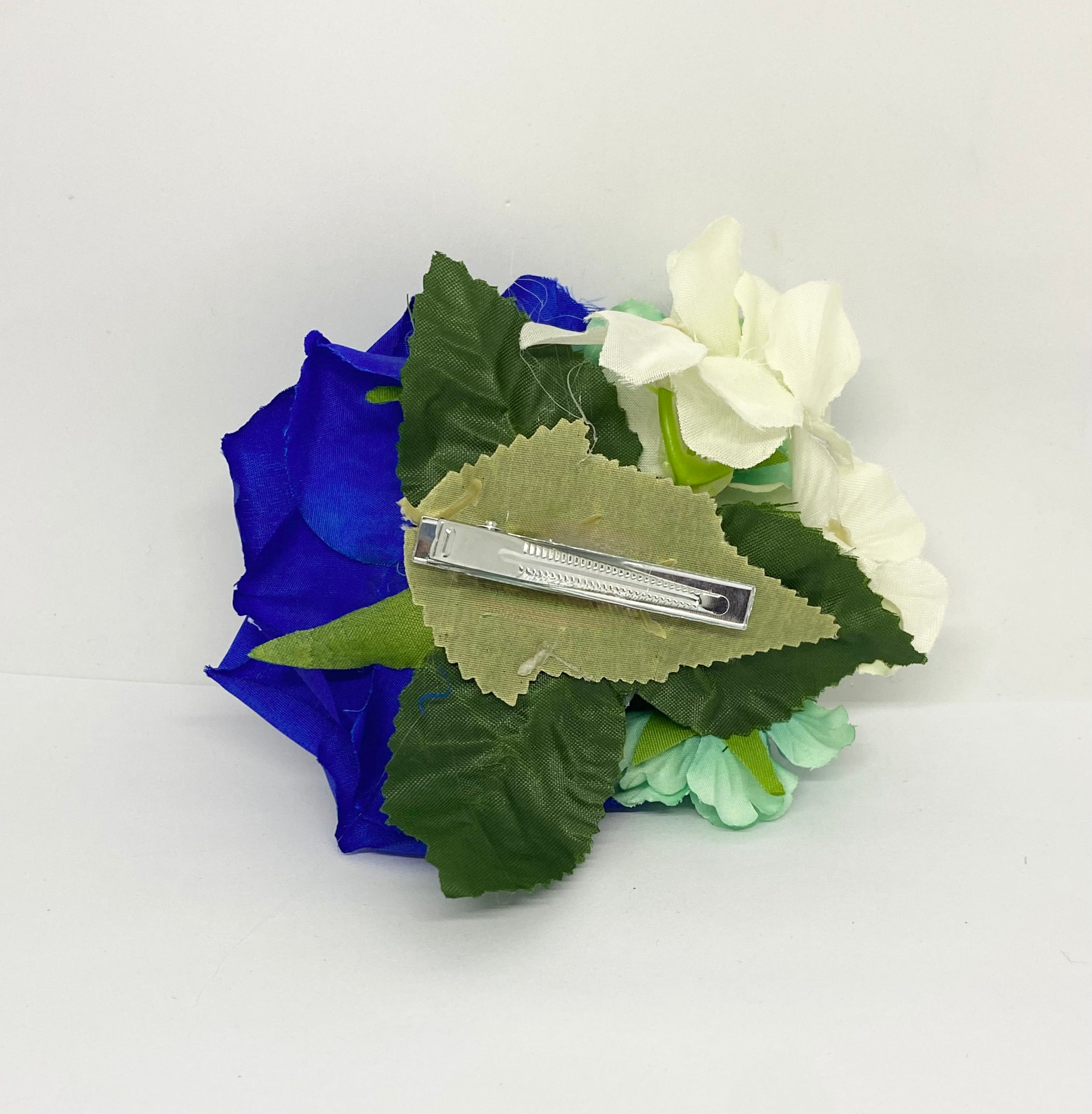 Blue fantasy swan rose 1940s/1950s hair flower A royal blue hair flower with a central rose and smaller mint leaves, attached to an alligator clip.