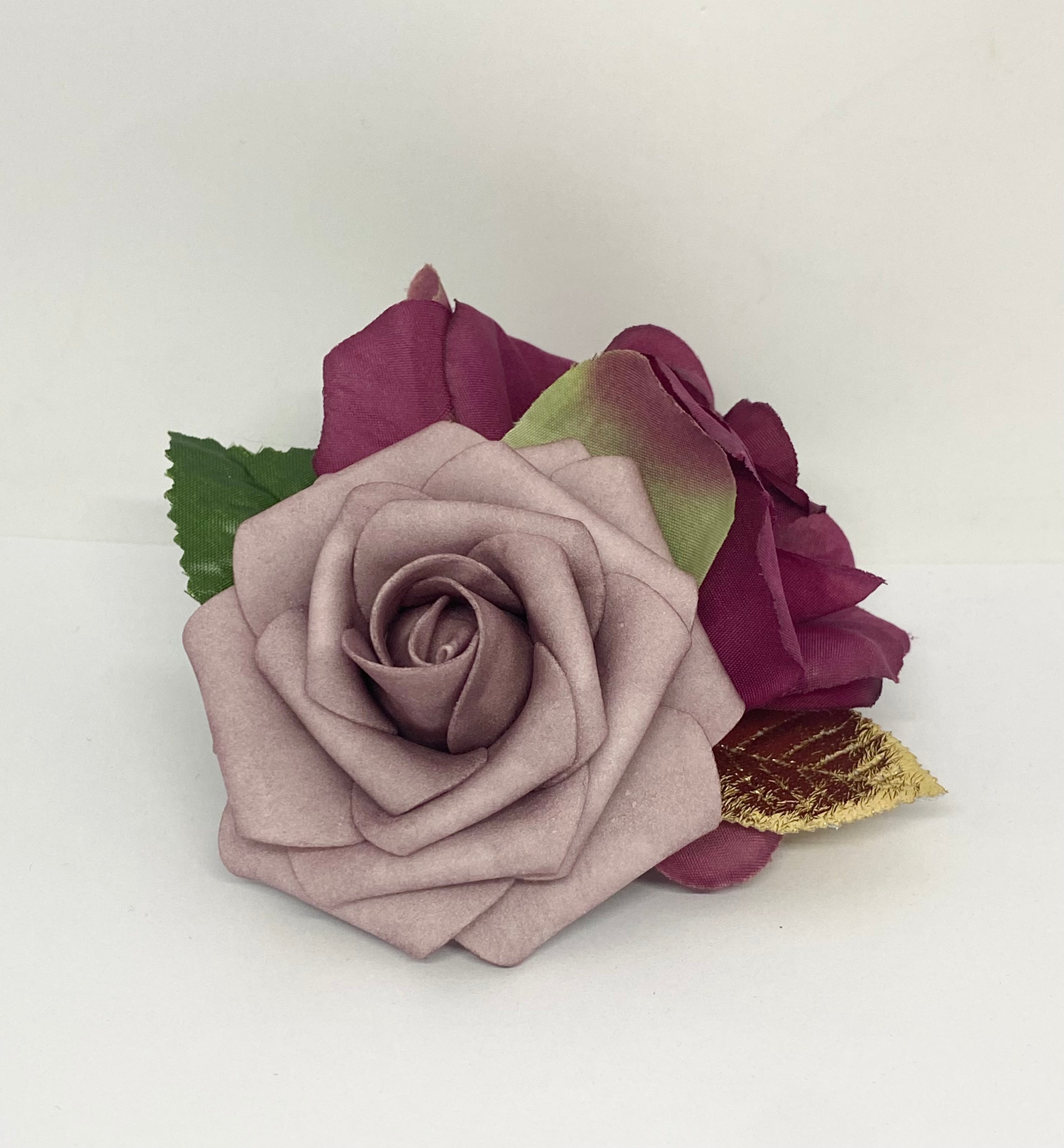 Burgundy Dream hair flower arrangement featuring a dark burgundy rose and a light purple rose with a gold accent, attached to a hair clip.