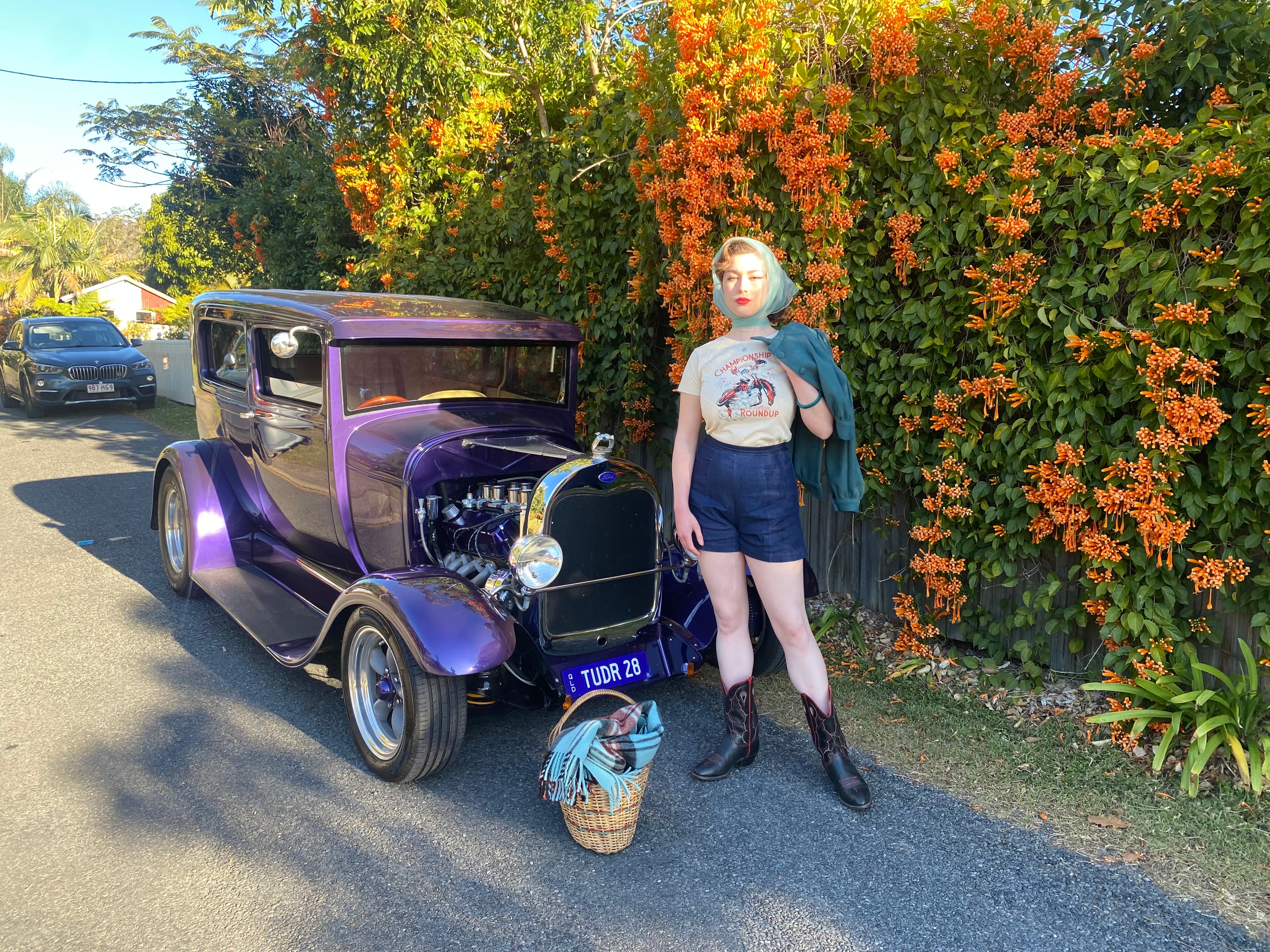  Championship round up vintage T-shirt and Pocket Denum Shorts next to a vintage purple car . Rockabilly Event