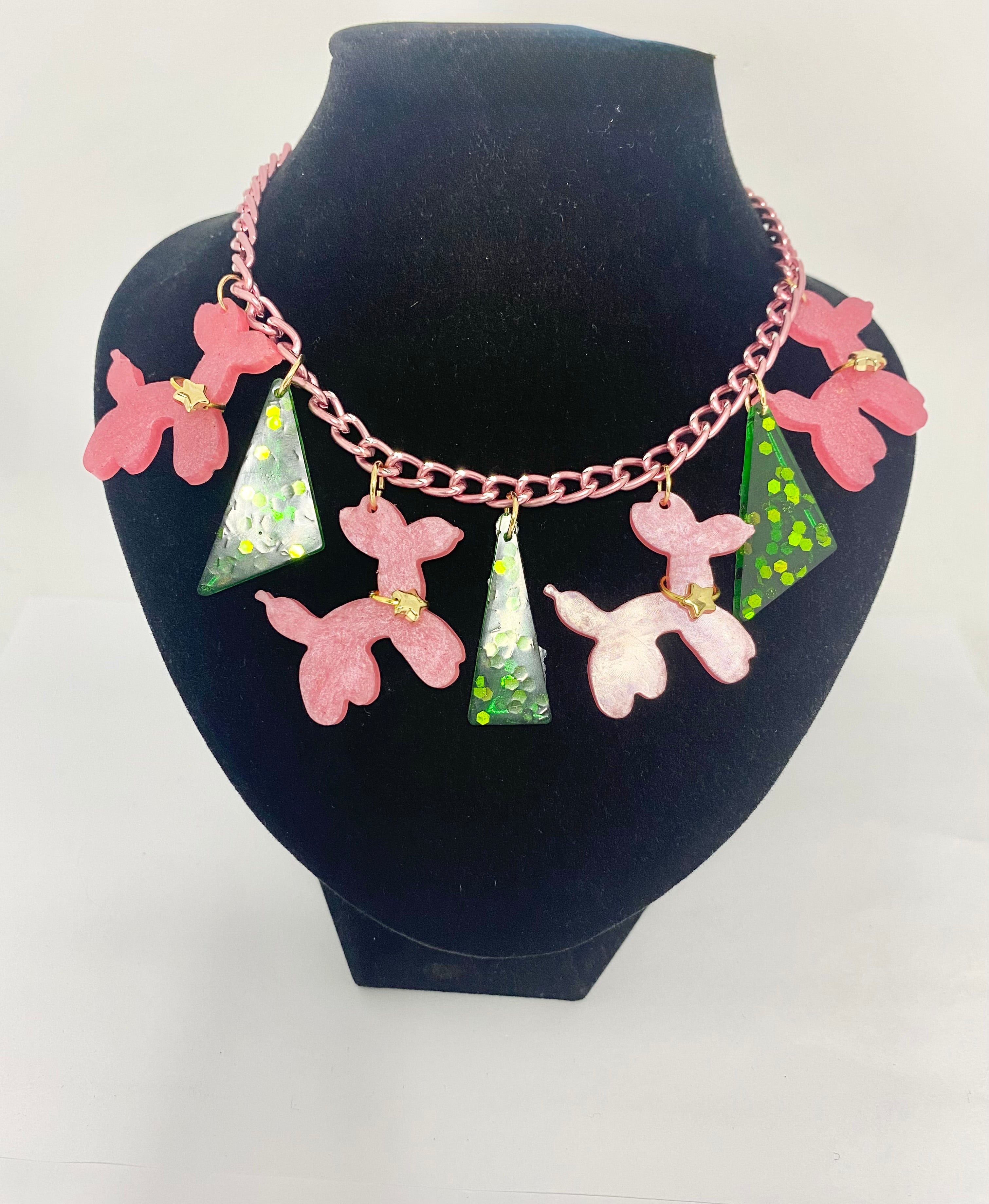 Circus poodles 1950s style whimsical fun Necklace with pink ballon dog poodles /and green pendants on a white background