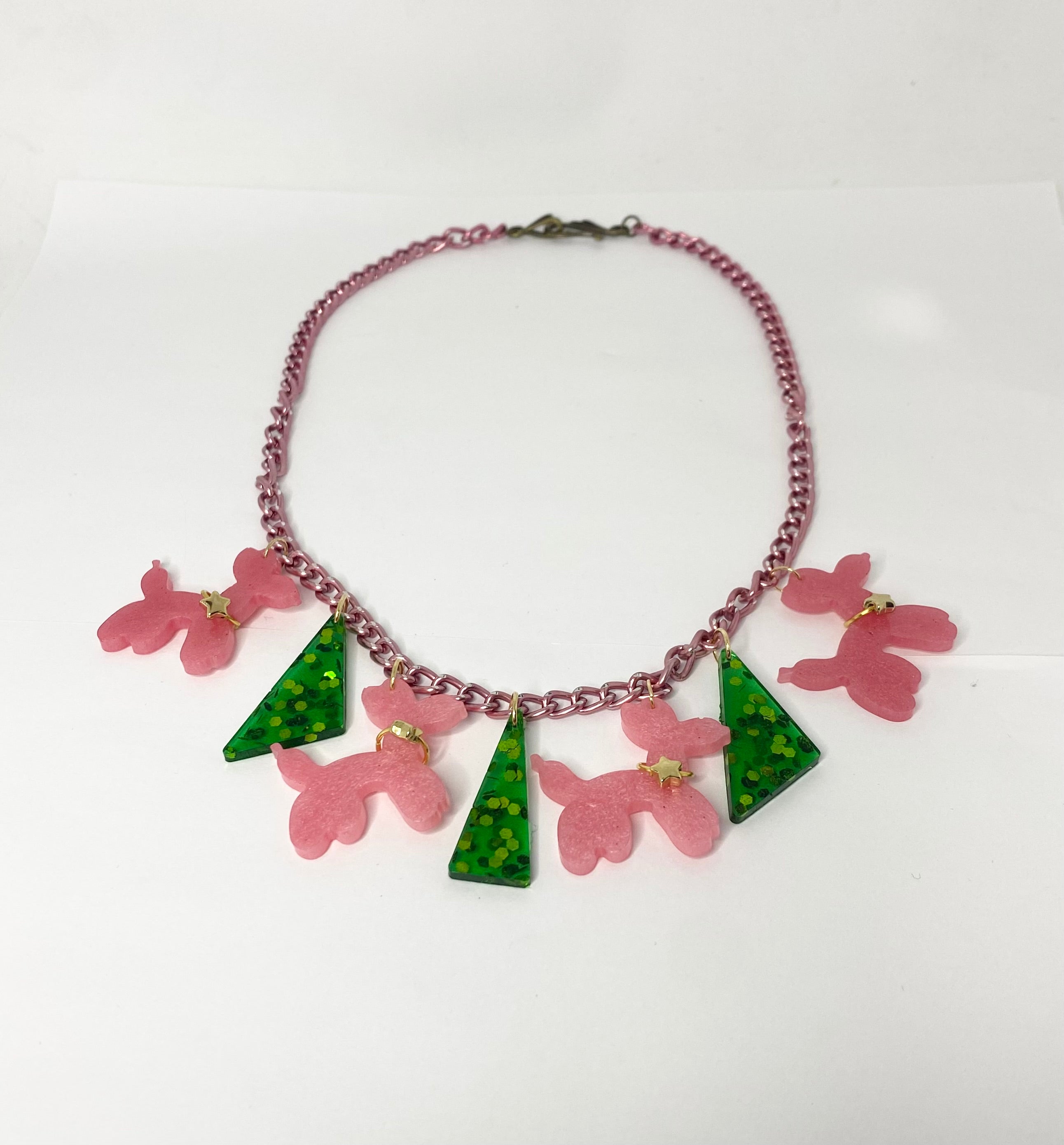Circus poodles 1950s style whimsical fun Necklace with pink floral and green leaf pendants on a white background