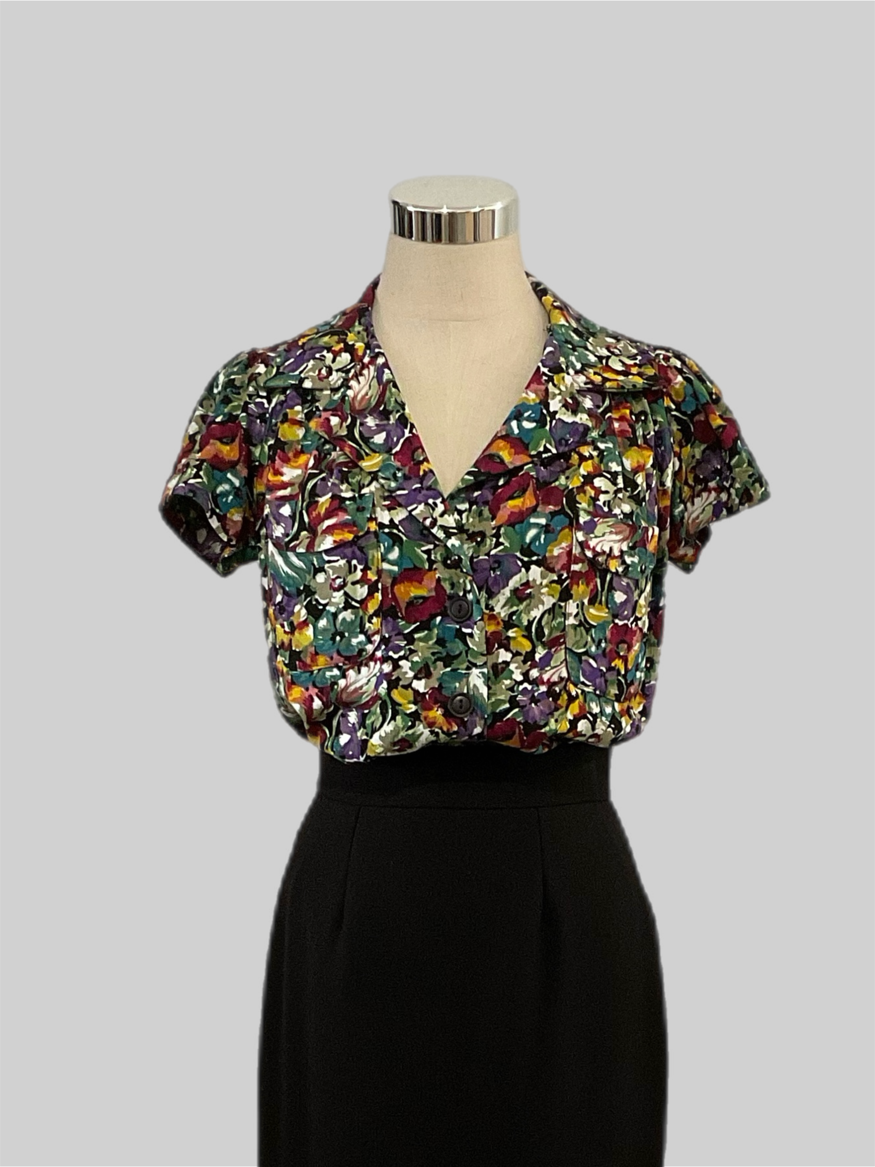Evita Savanna 1940s  vintage style short sleeve blouse with patch pockets, featuring a multicolor  floral print, displayed on a mannequin.
