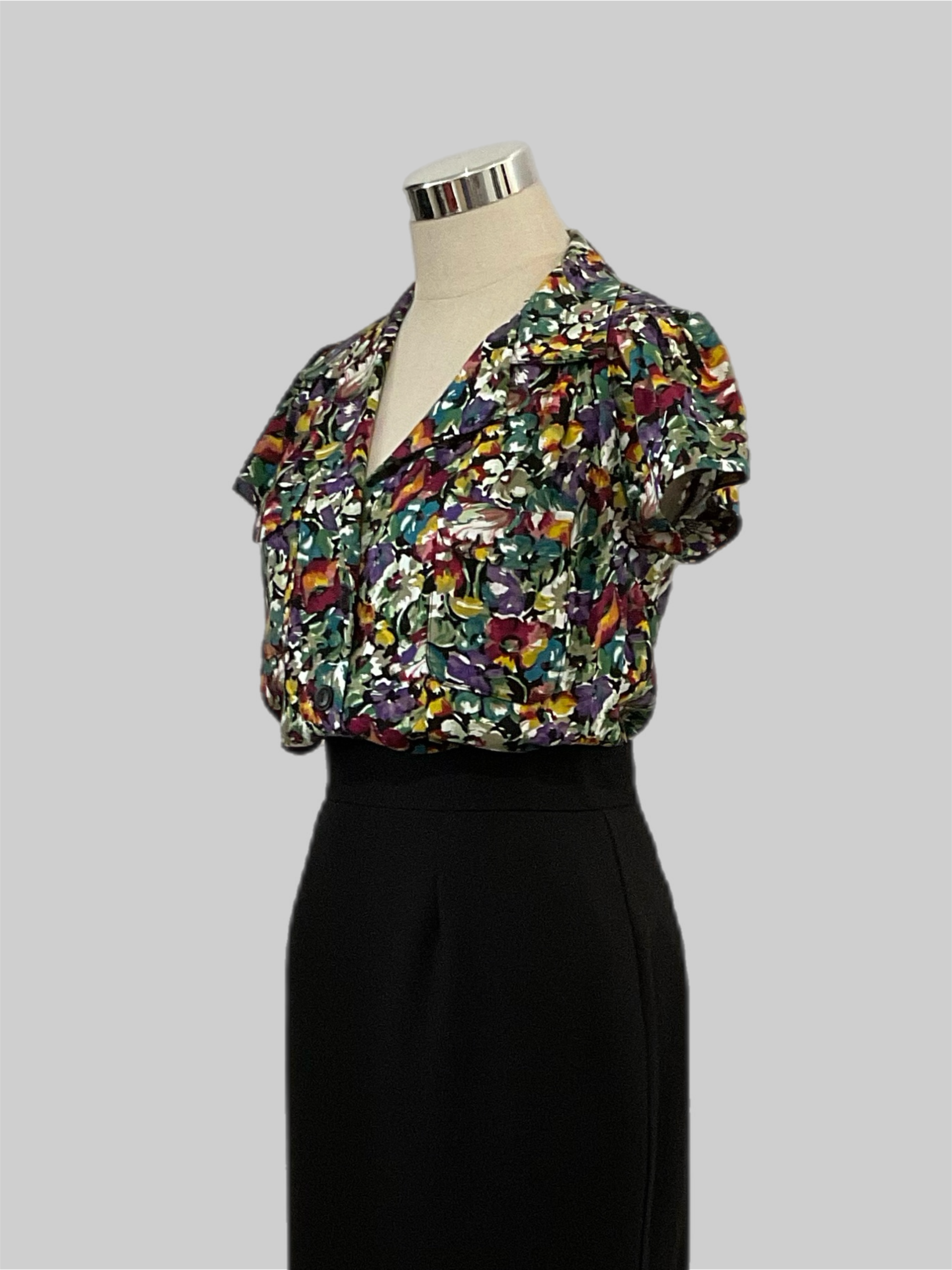 Evita Savanna 1940s  vintage style short sleeve blouse with patch pockets, featuring a multicolor  floral print, displayed on a mannequin.
