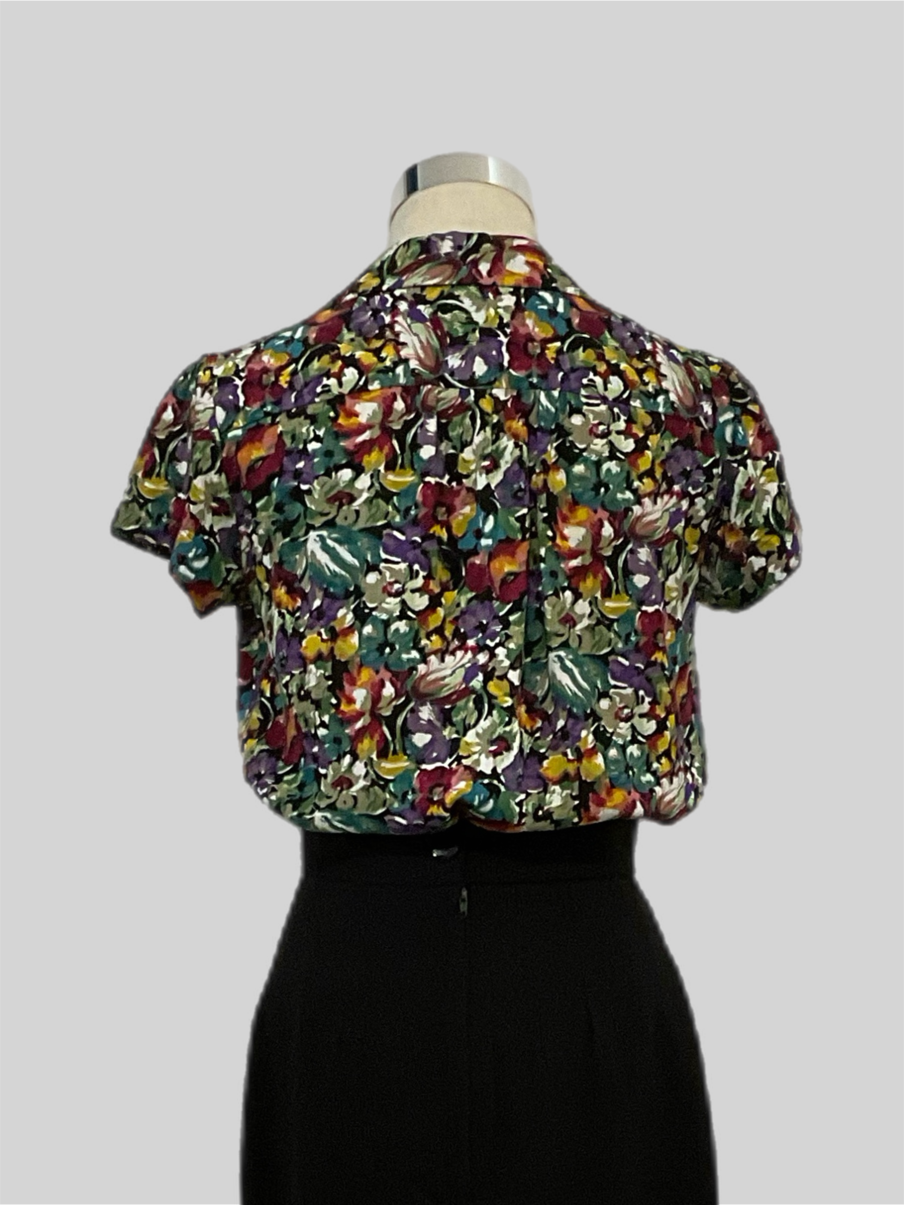 Evita Savanna 1940s  vintage style short sleeve blouse with patch pockets, featuring a multicolor  floral print, displayed on a mannequin.