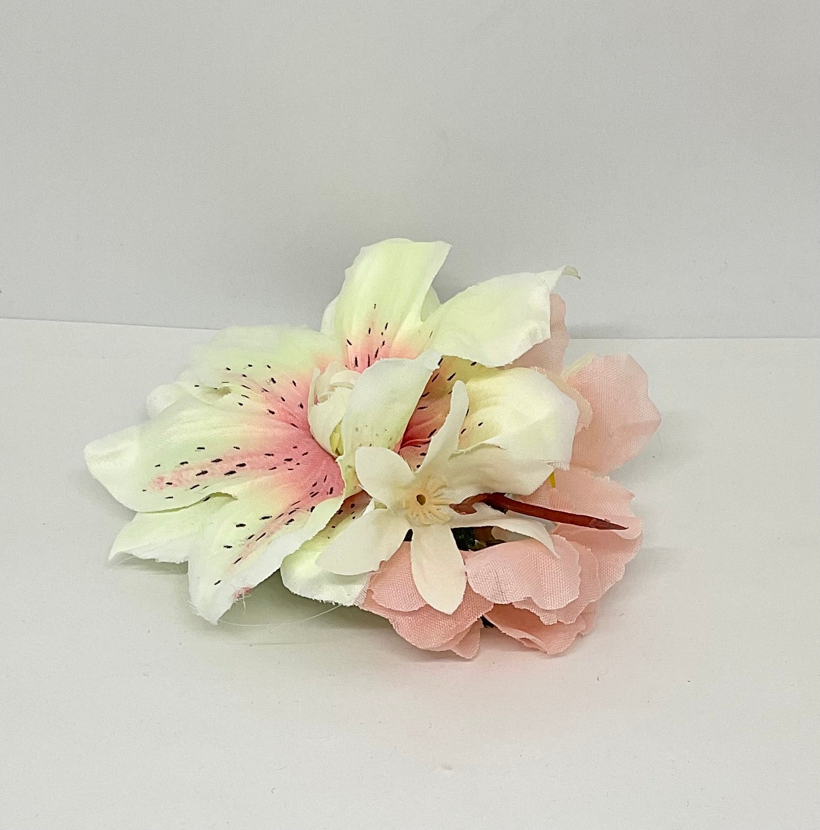 Lilly and Blossom vintage pin-up style hair flower accessory with white and pink petals, featuring a large central flower with black speckles, accompanied by smaller petals.