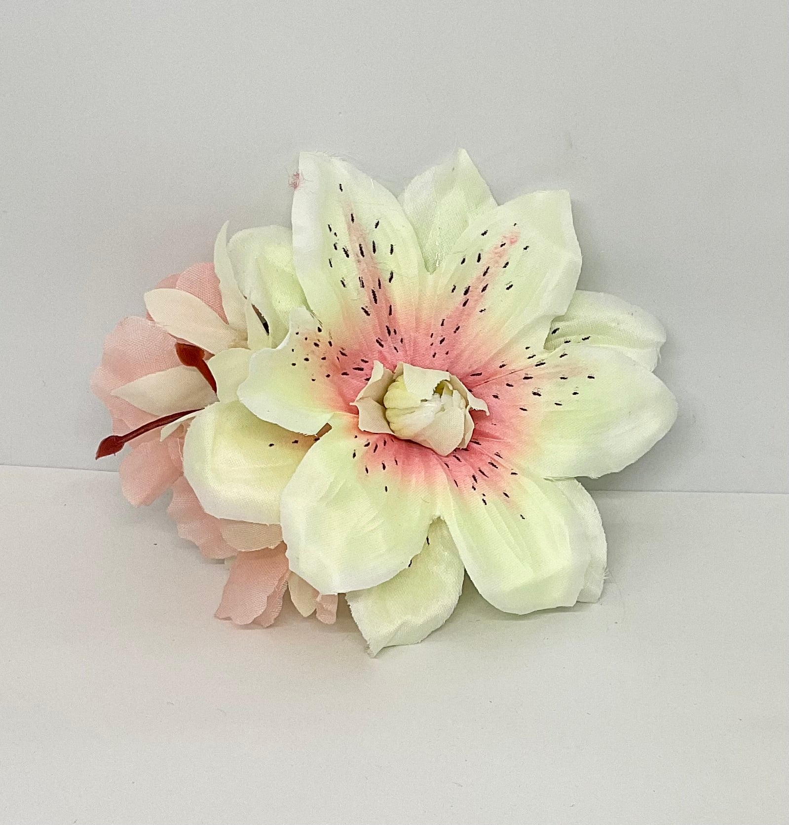 Lilly and Blossom vintage pin-up style hair flower accessory with white and pink petals, featuring a large central flower with black speckles, accompanied by smaller petals.