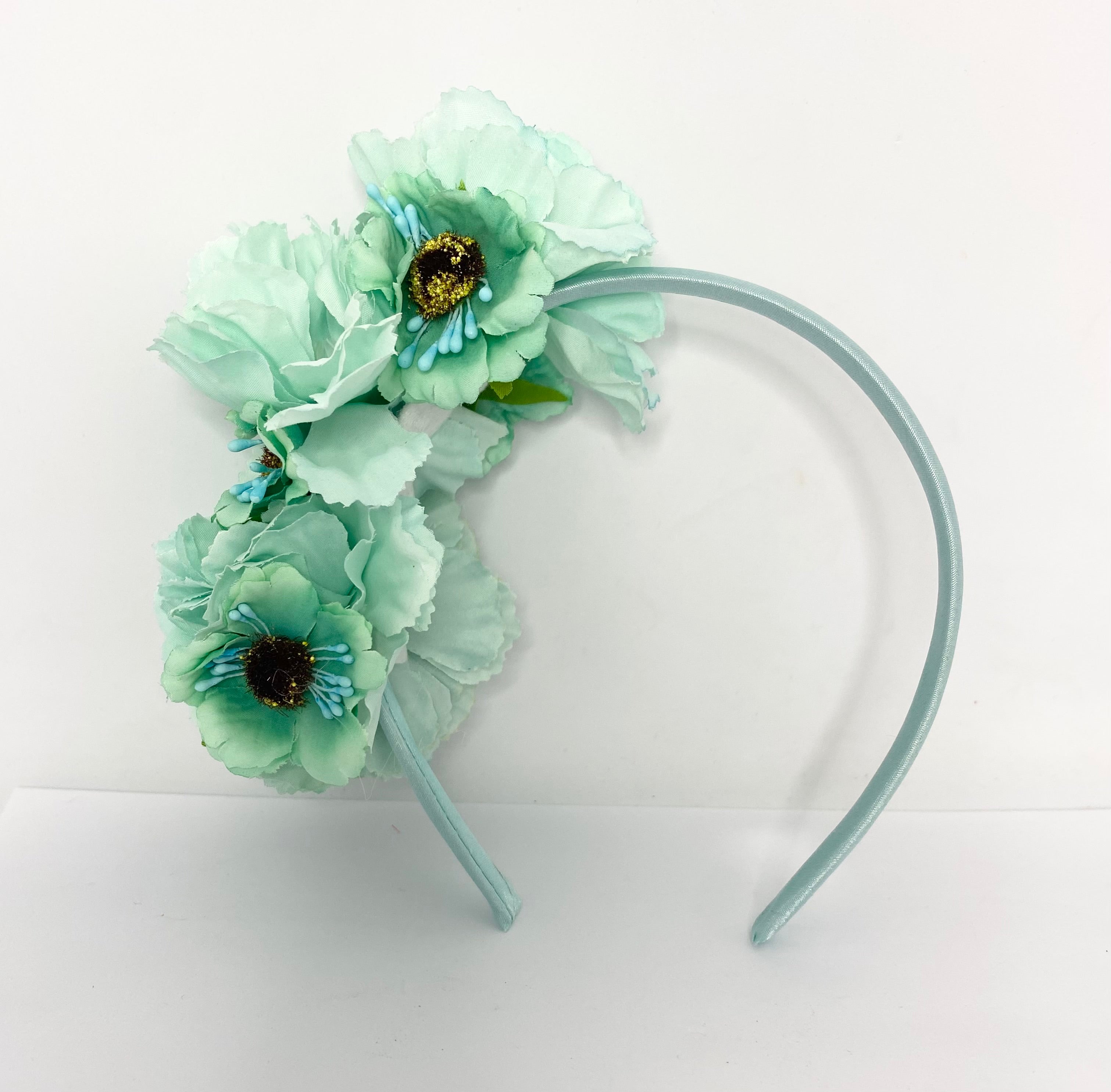 Mint flower  headband on a white background, vintage race-day styling.