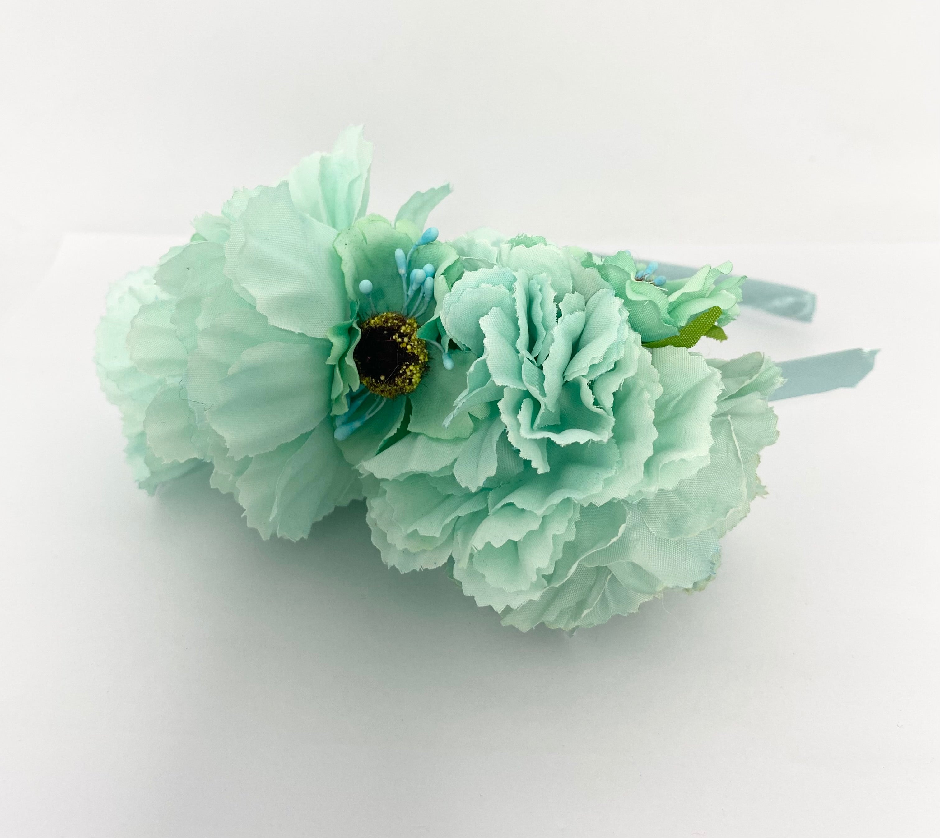 Mint flower  headband on a white background, vintage race-day styling.