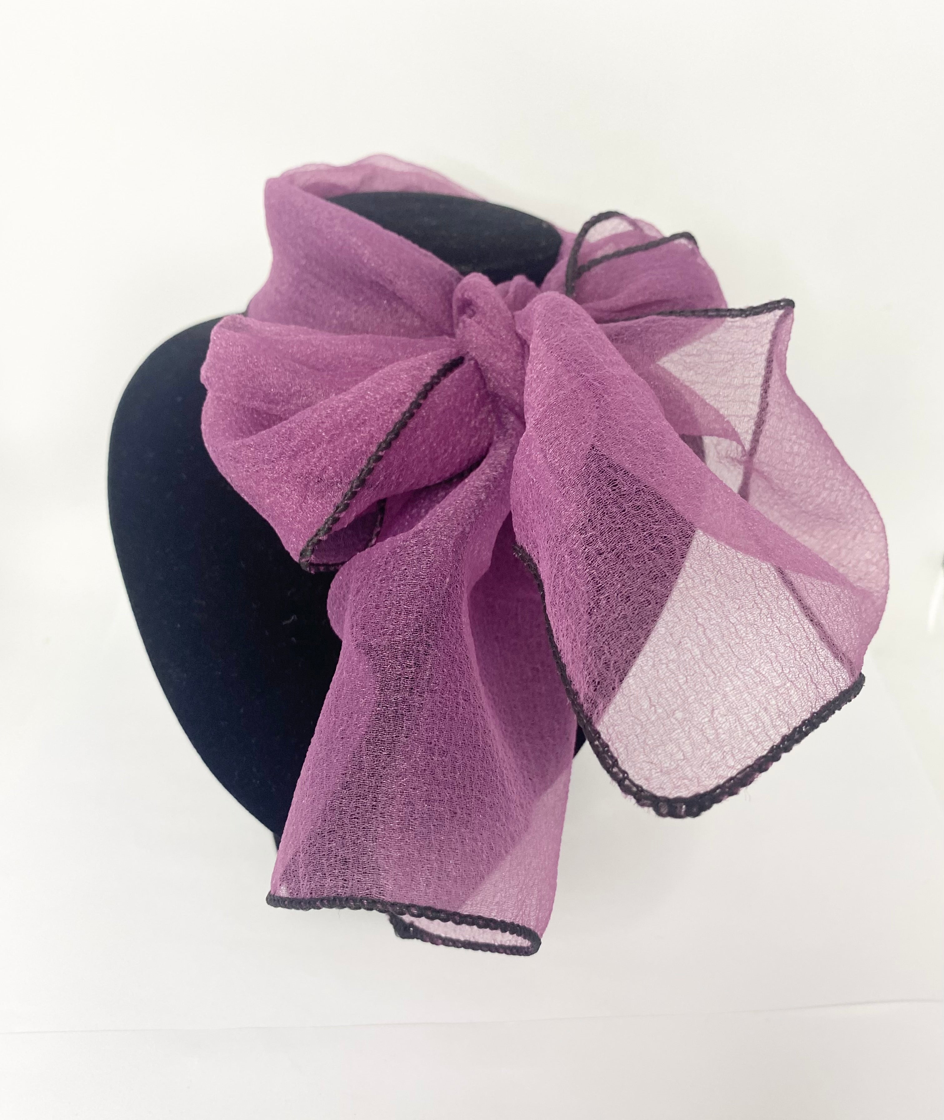 Organza plum-vintage style hair or necktie.Purple bow headband on a mannequin head with a white background