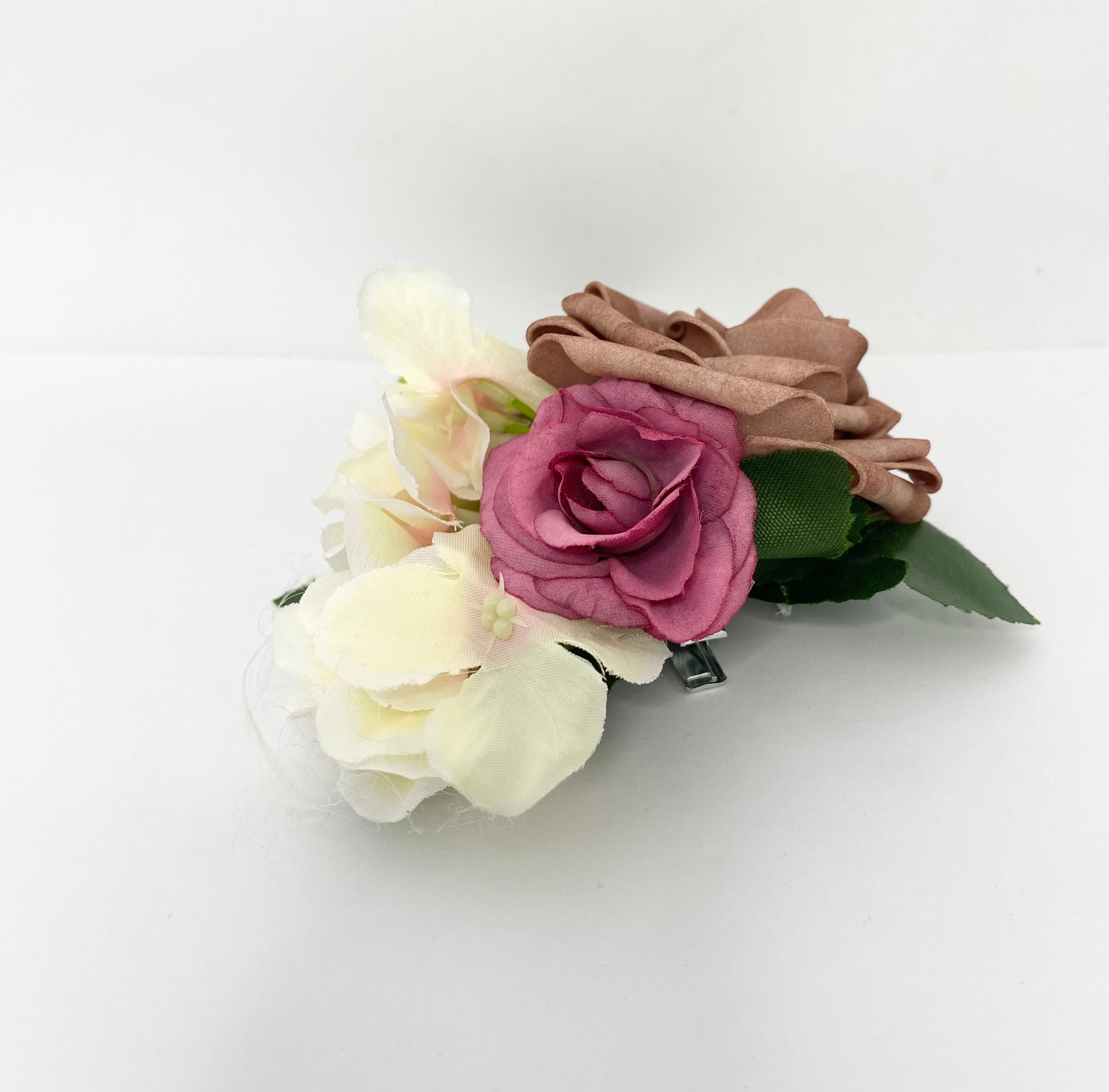 Floral hair clip with pink, white, and brown flowers on a white background