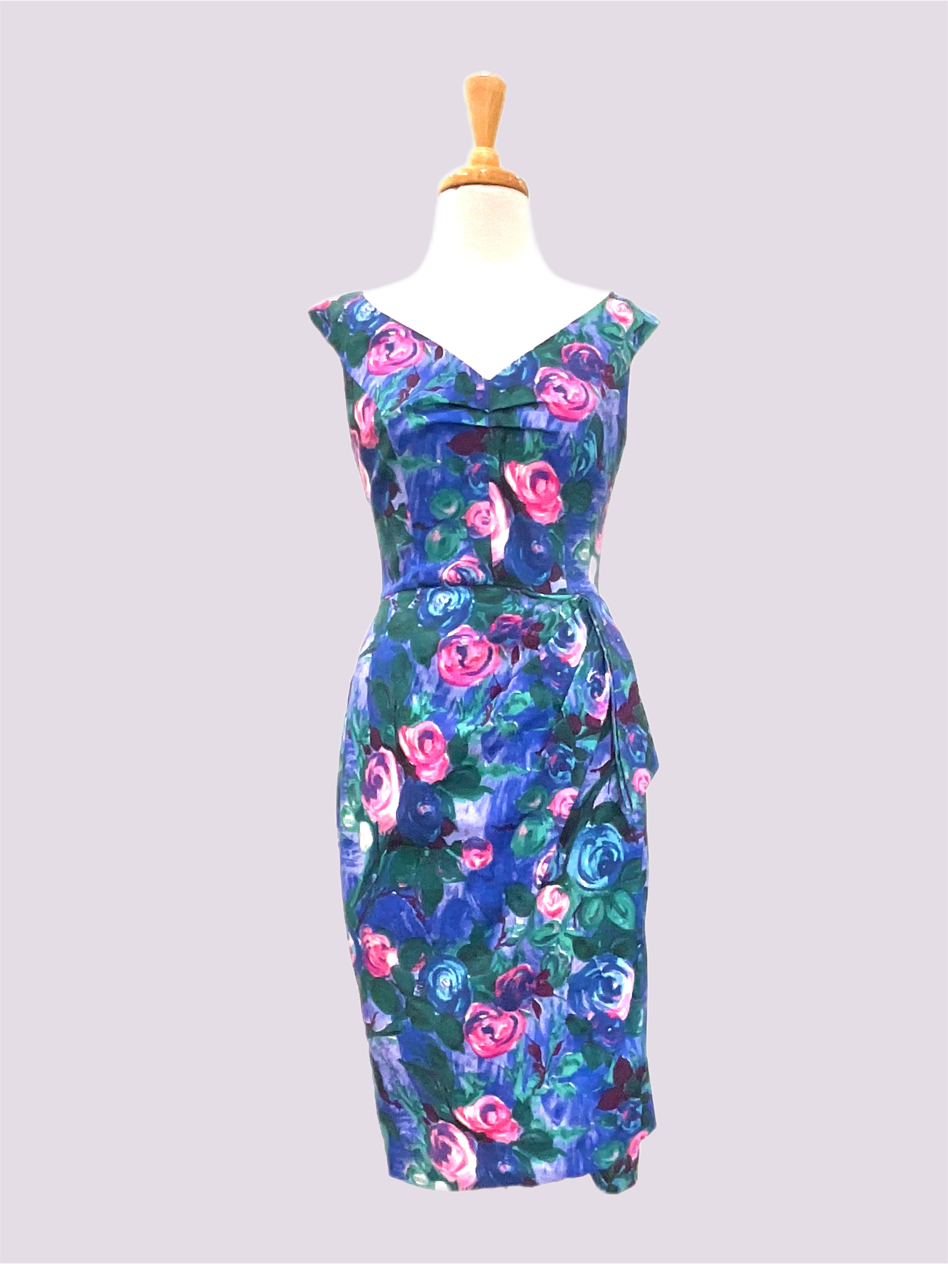 Ruby Anne 1950s Vintage style blue floral print dress with a deep v-neck and cap sleeve look, featuring a princess seam bodice and a wrap skirt with a side tie.