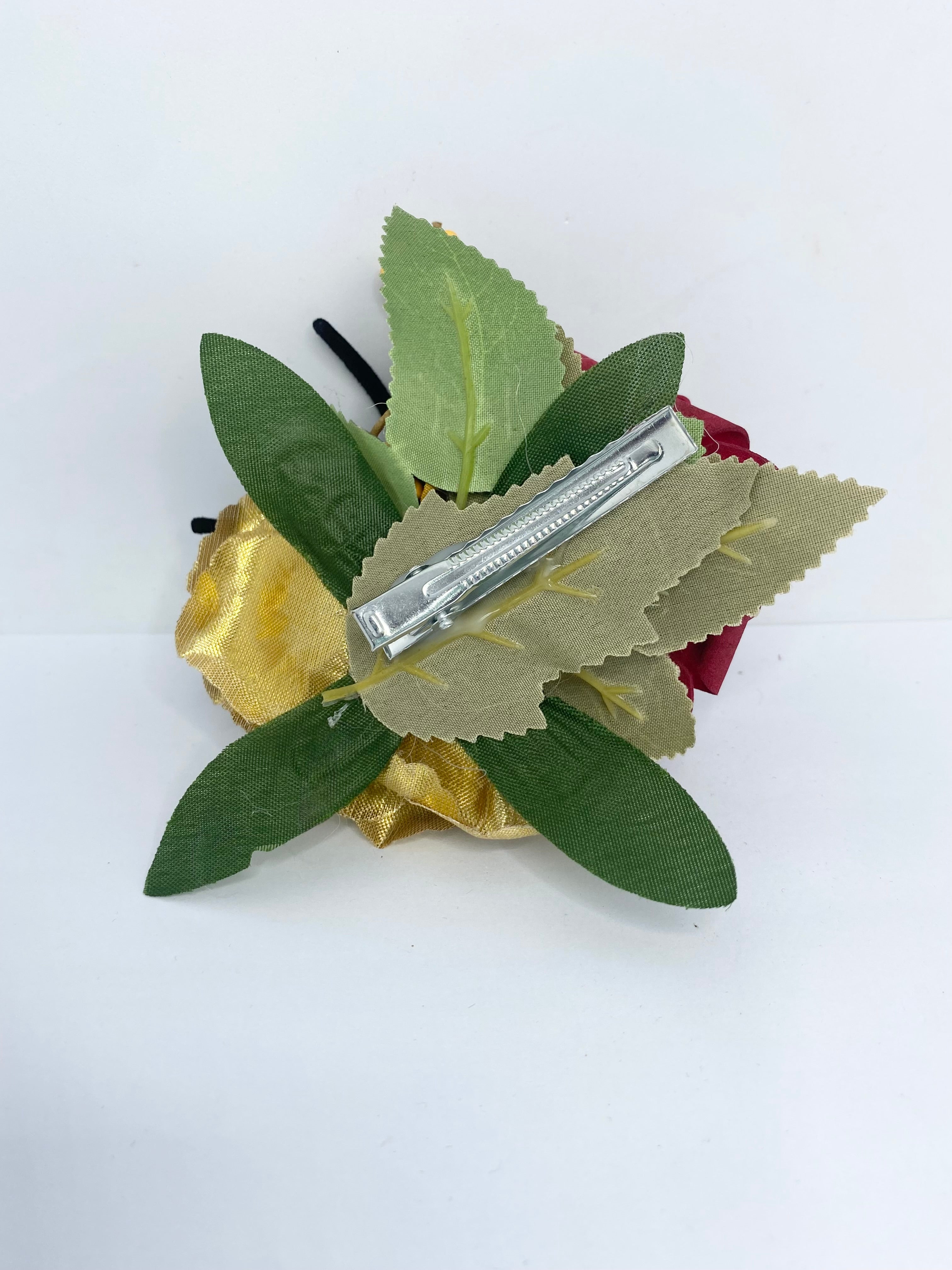 Spooky red and gold rose 1940s/1950s Halloween Hair Flower Decorative flower brooch with a red rose, gold ribbon, and black spider on a white background