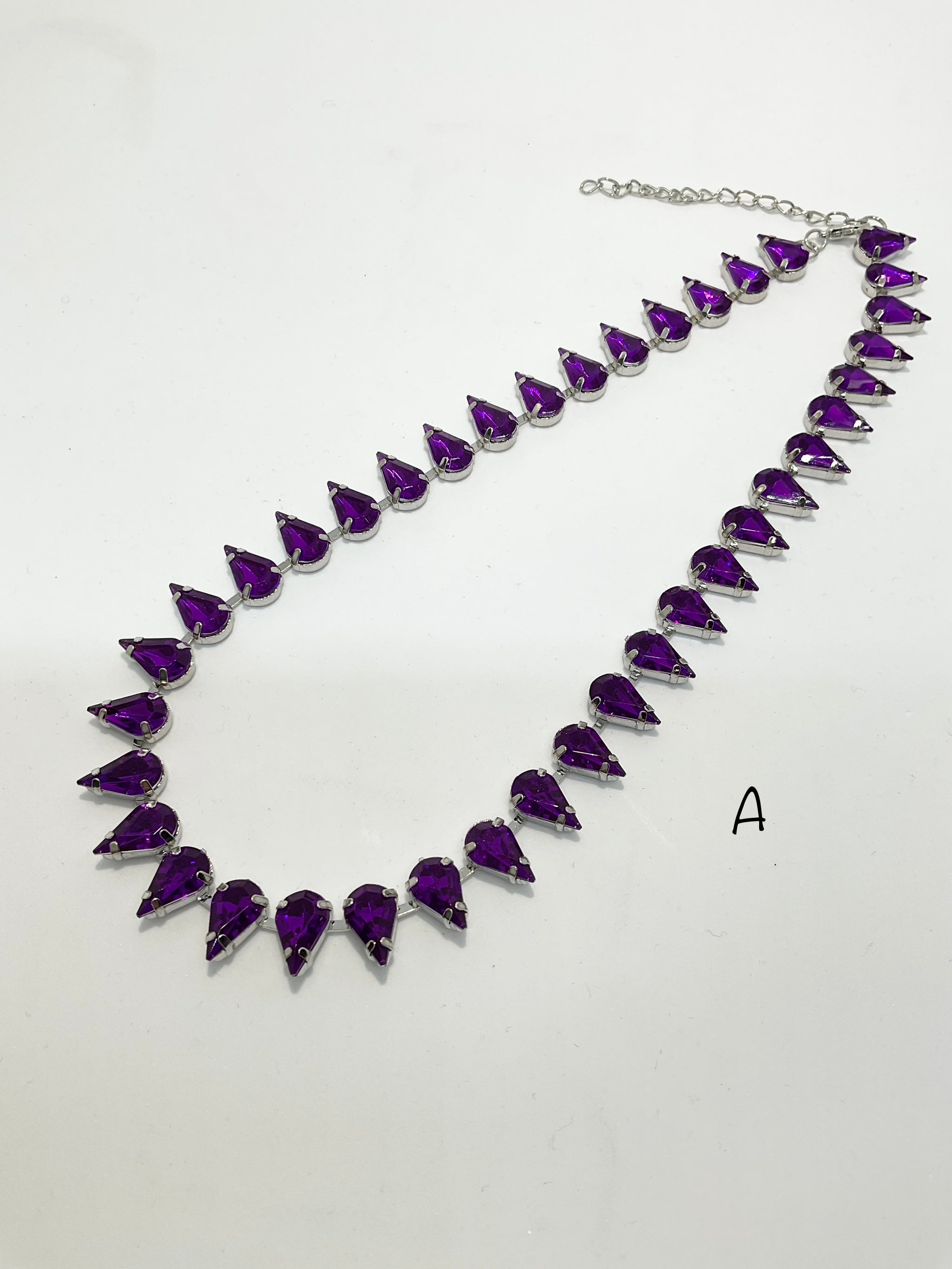 A teardrop-shaped purple vintage style necklace with adjustable chain length, displayed against a white background.