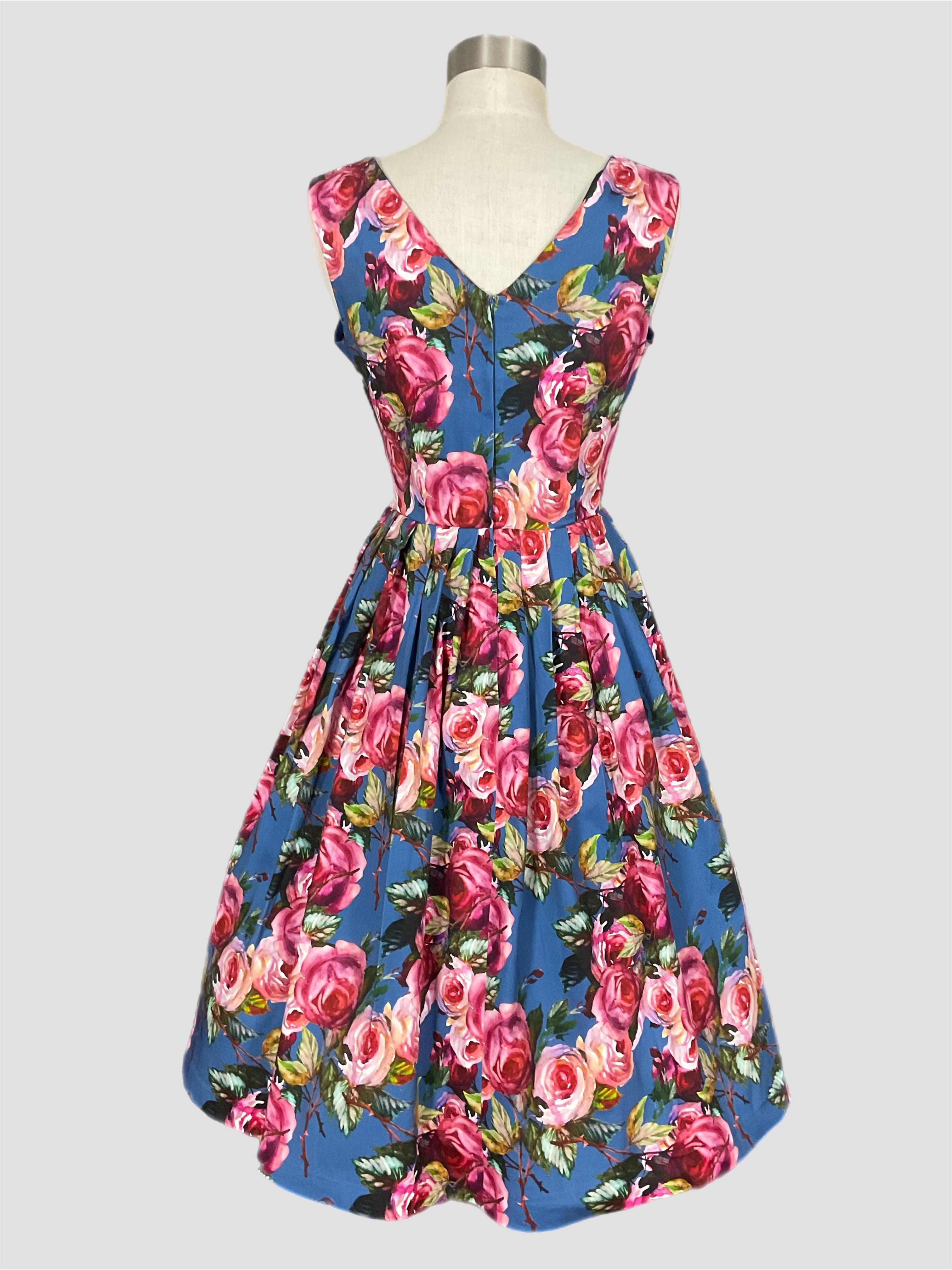 Vivian Carolina garden pink rose print floral Dress on a blue background. Spring summer dress