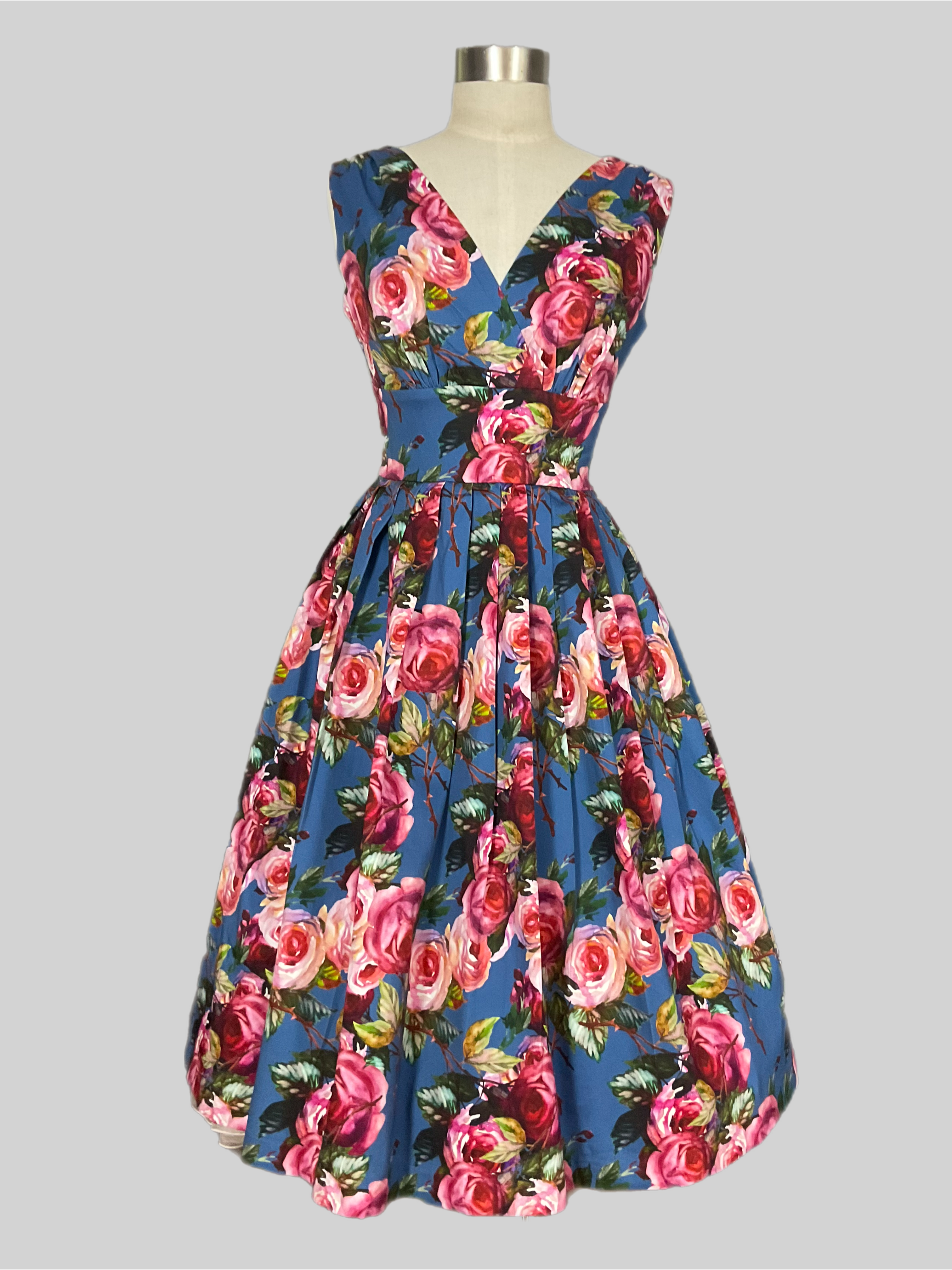Vivian Carolina garden pink rose print floral Dress on a blue background. Spring summer dress
