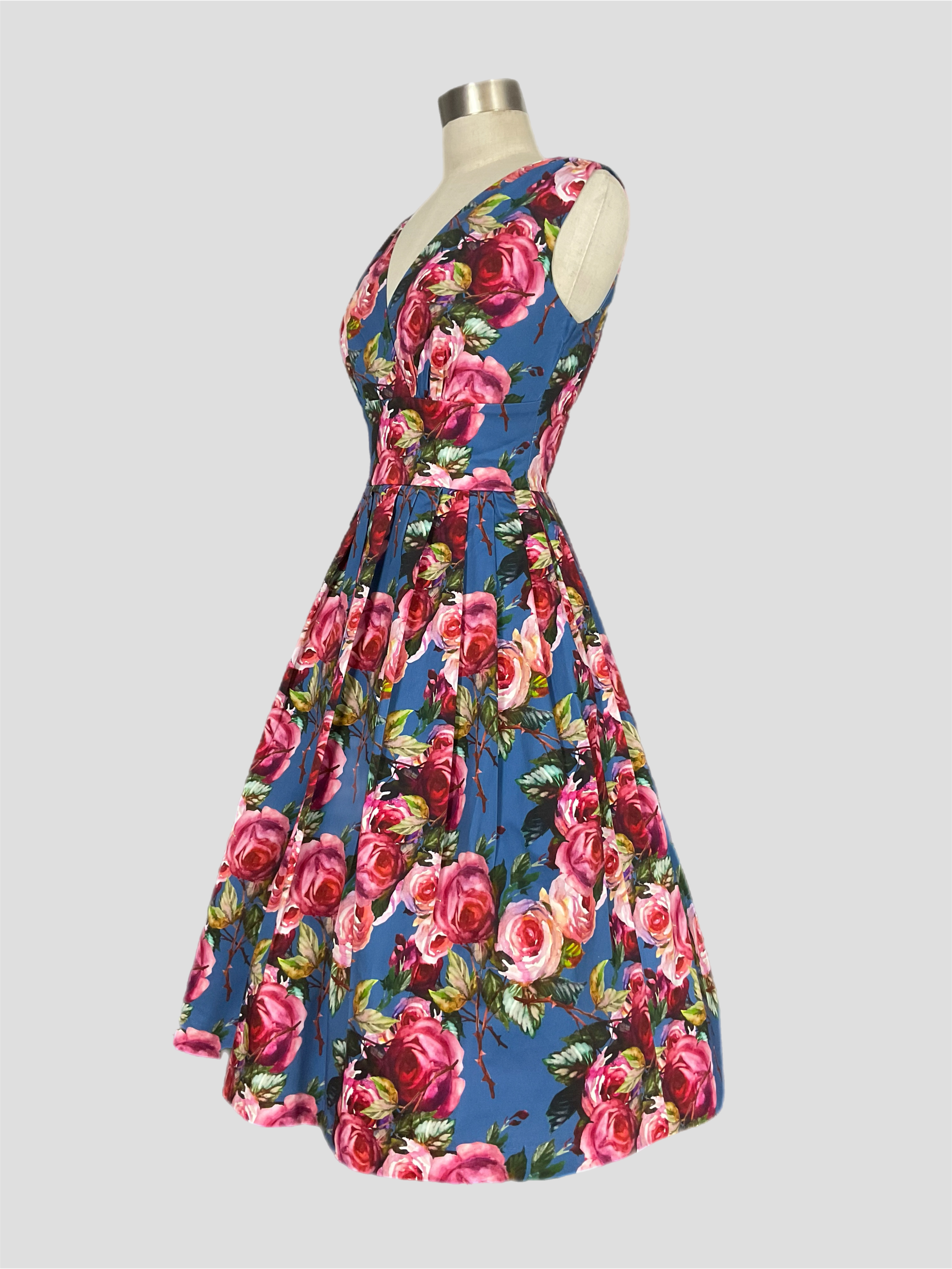 Vivian Carolina garden pink rose print floral Dress on a blue background. Spring summer dress